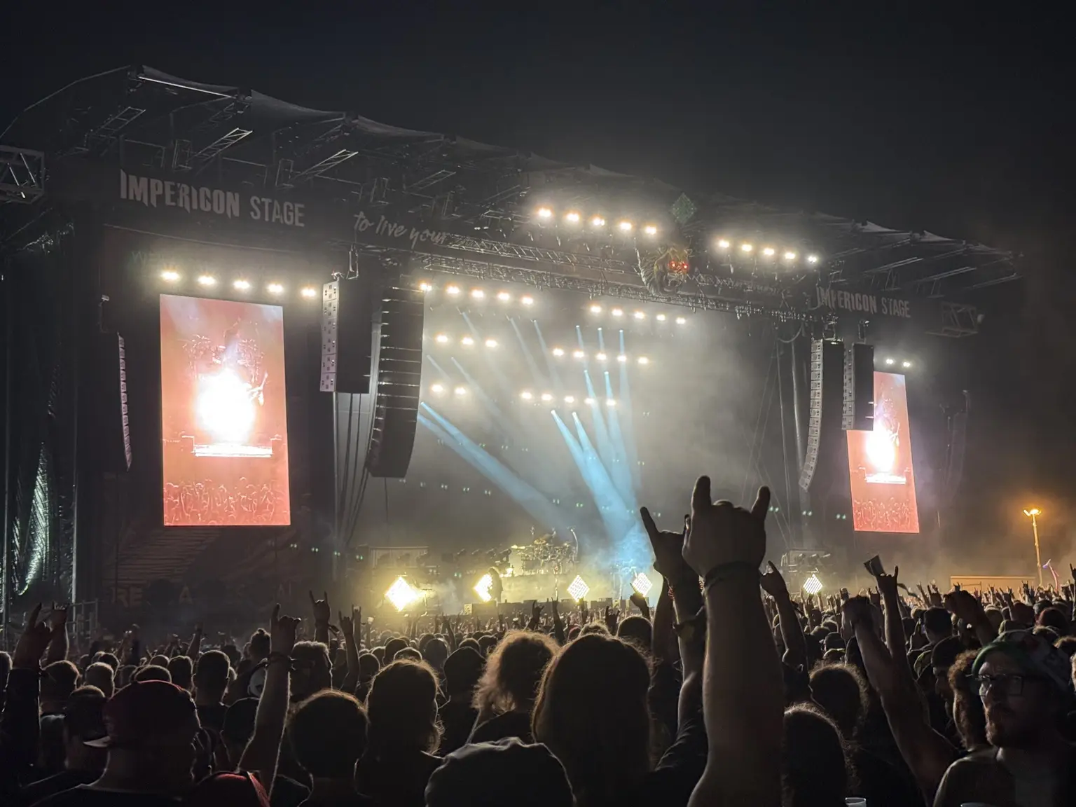 Large festival stage with an audience and live video of the performance on two side LED walls